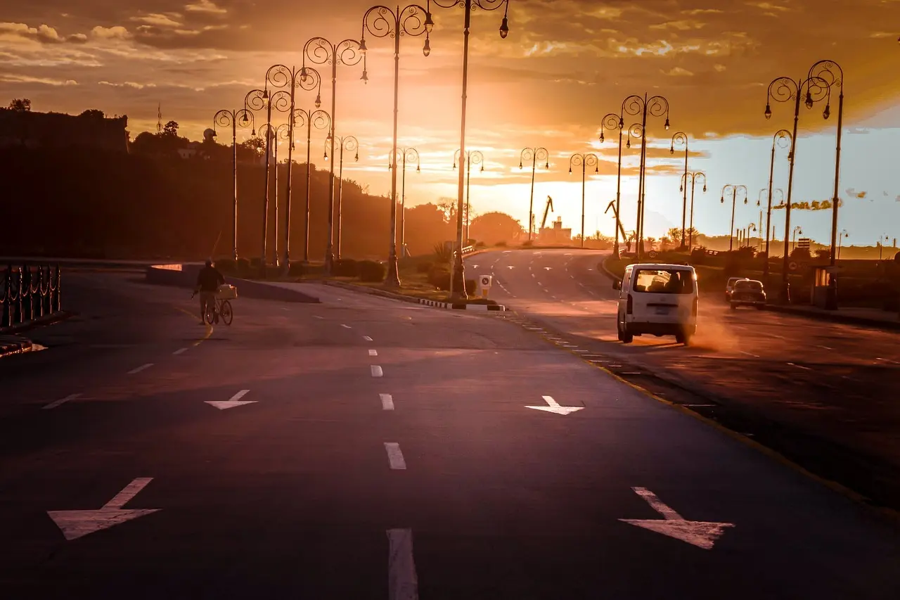 Cyklist på åben vej ved solnedgang